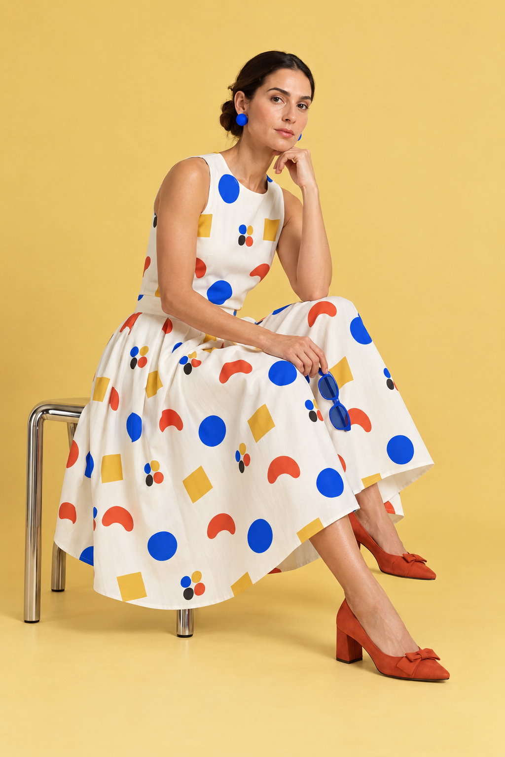 Seated full-skirt dress in the CUT / REPEAT textile against a warm yellow background.