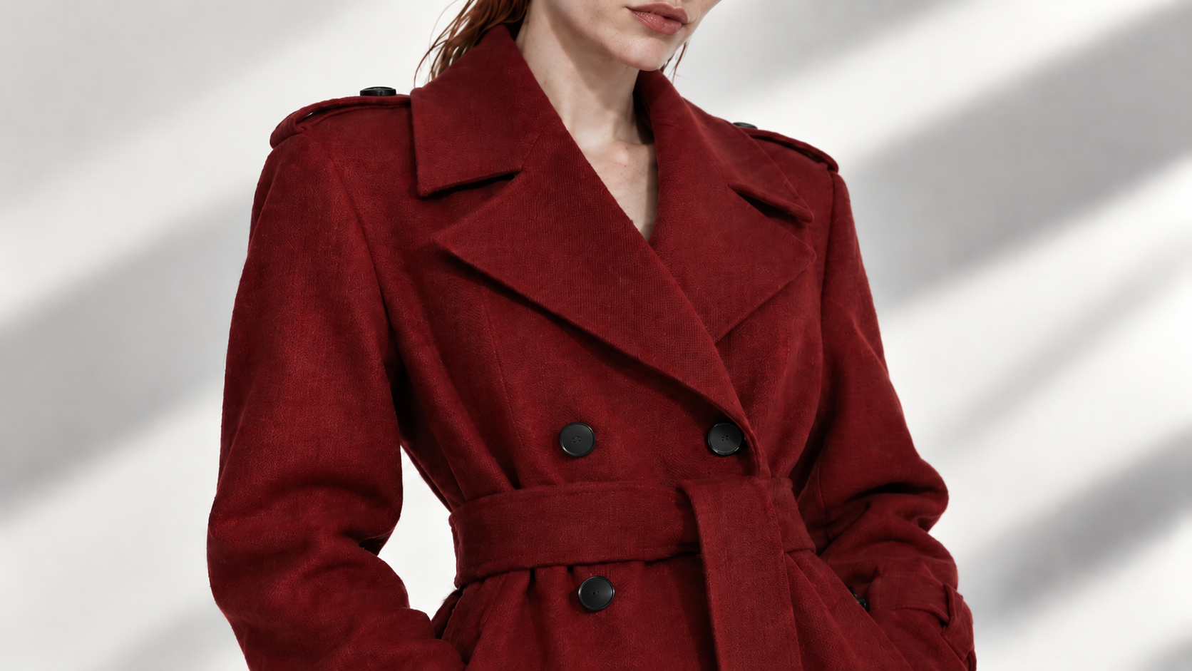 Medium view showing the belted construction and tailoring of the crimson coat.